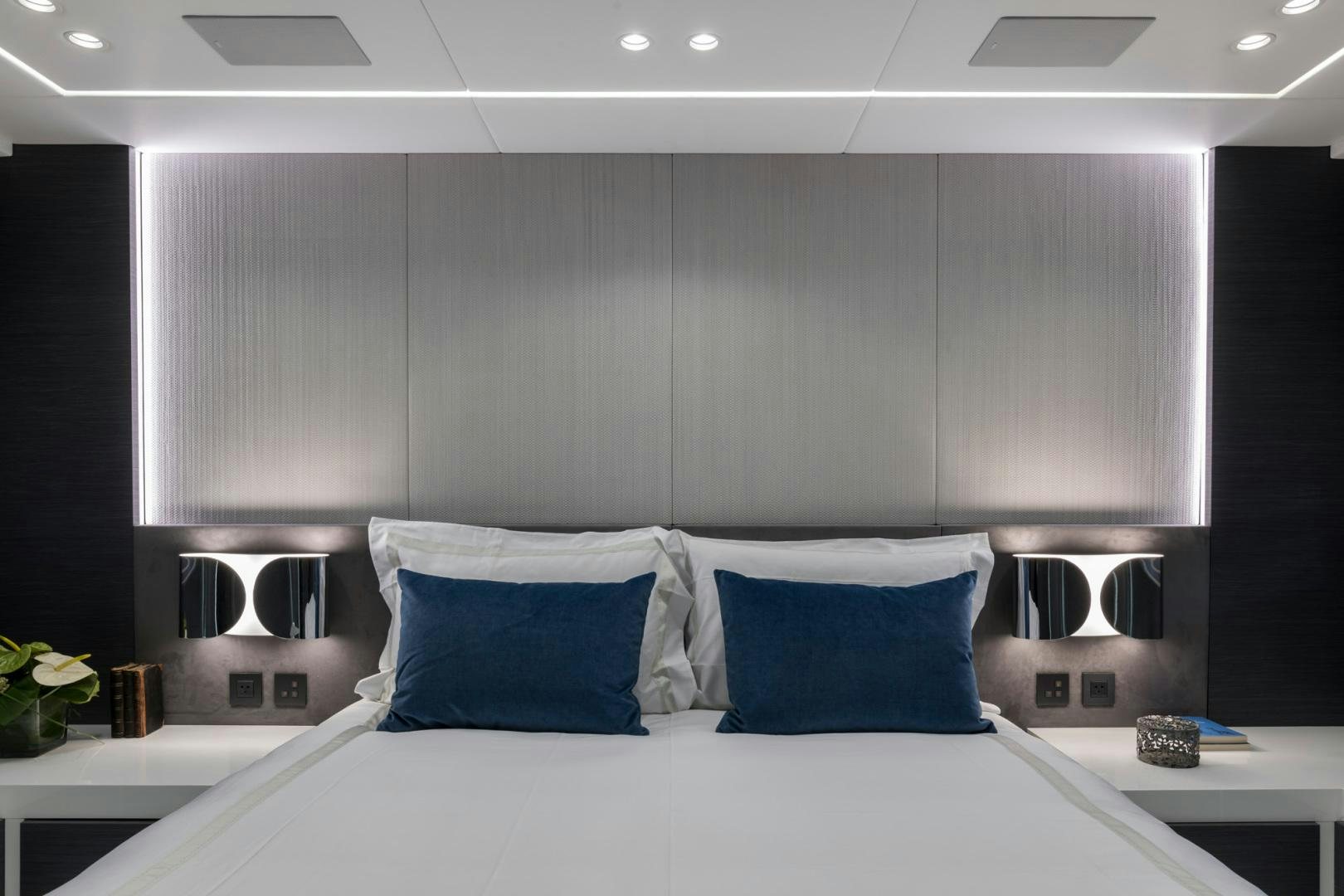 a white bed with blue pillows aboard NANA I Yacht for Sale