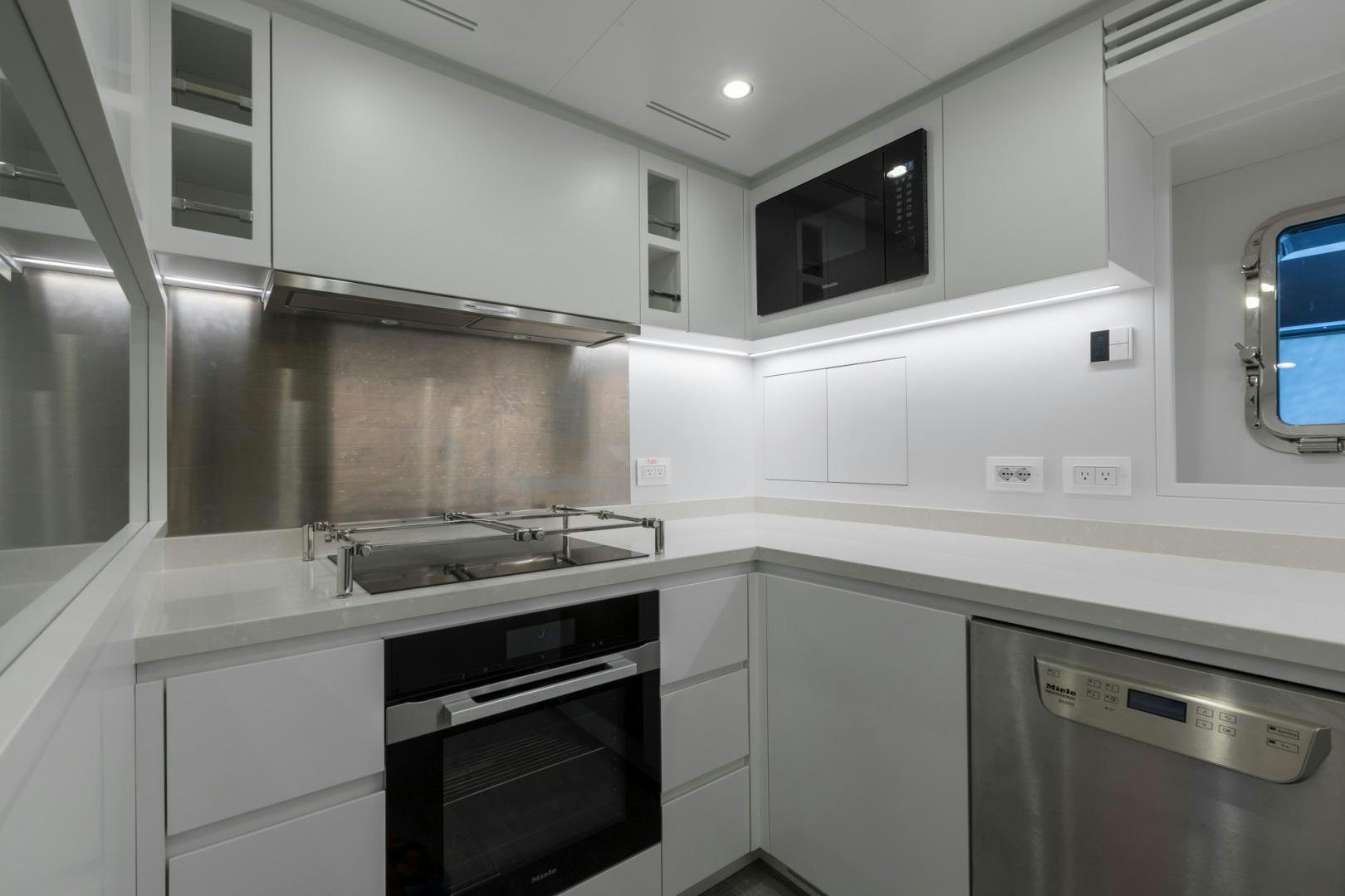 a kitchen with white cabinets aboard NANA I Yacht for Sale
