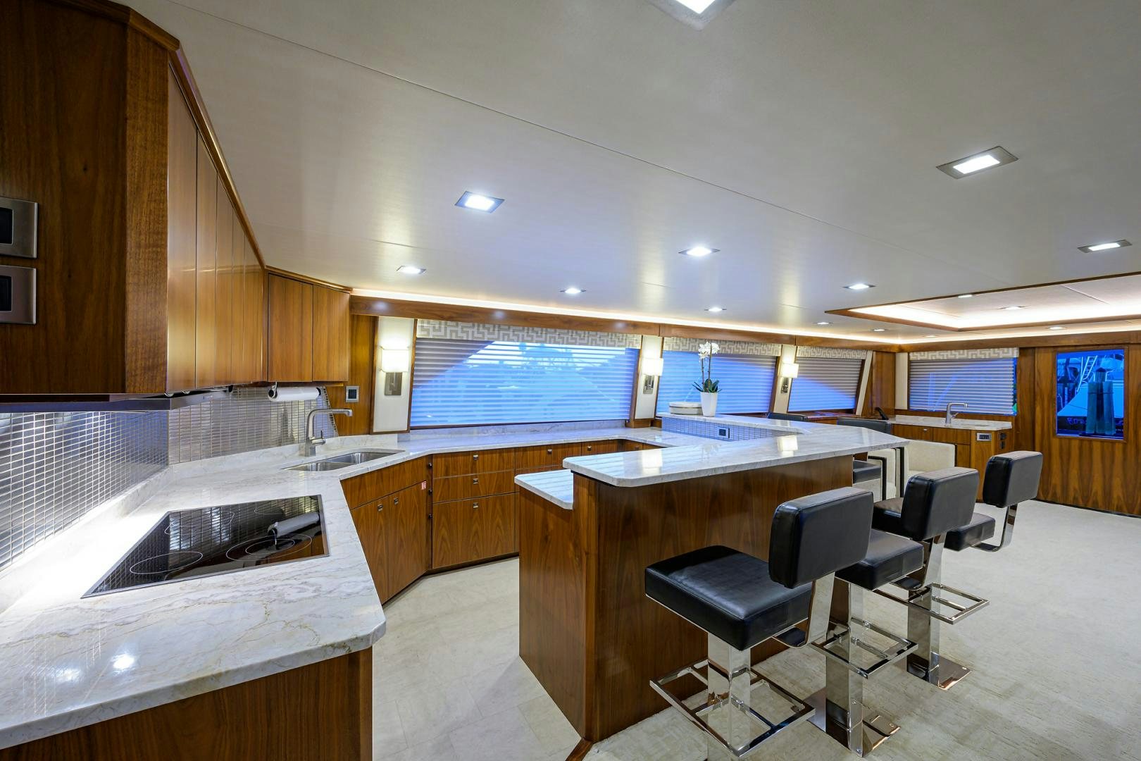 a kitchen with a bar and a bar stools aboard PASTIME Yacht for Sale