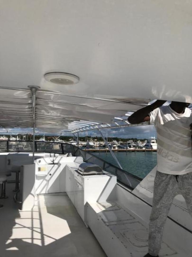 a person standing on a deck looking at a city aboard TRUE NORTH Yacht for Sale
