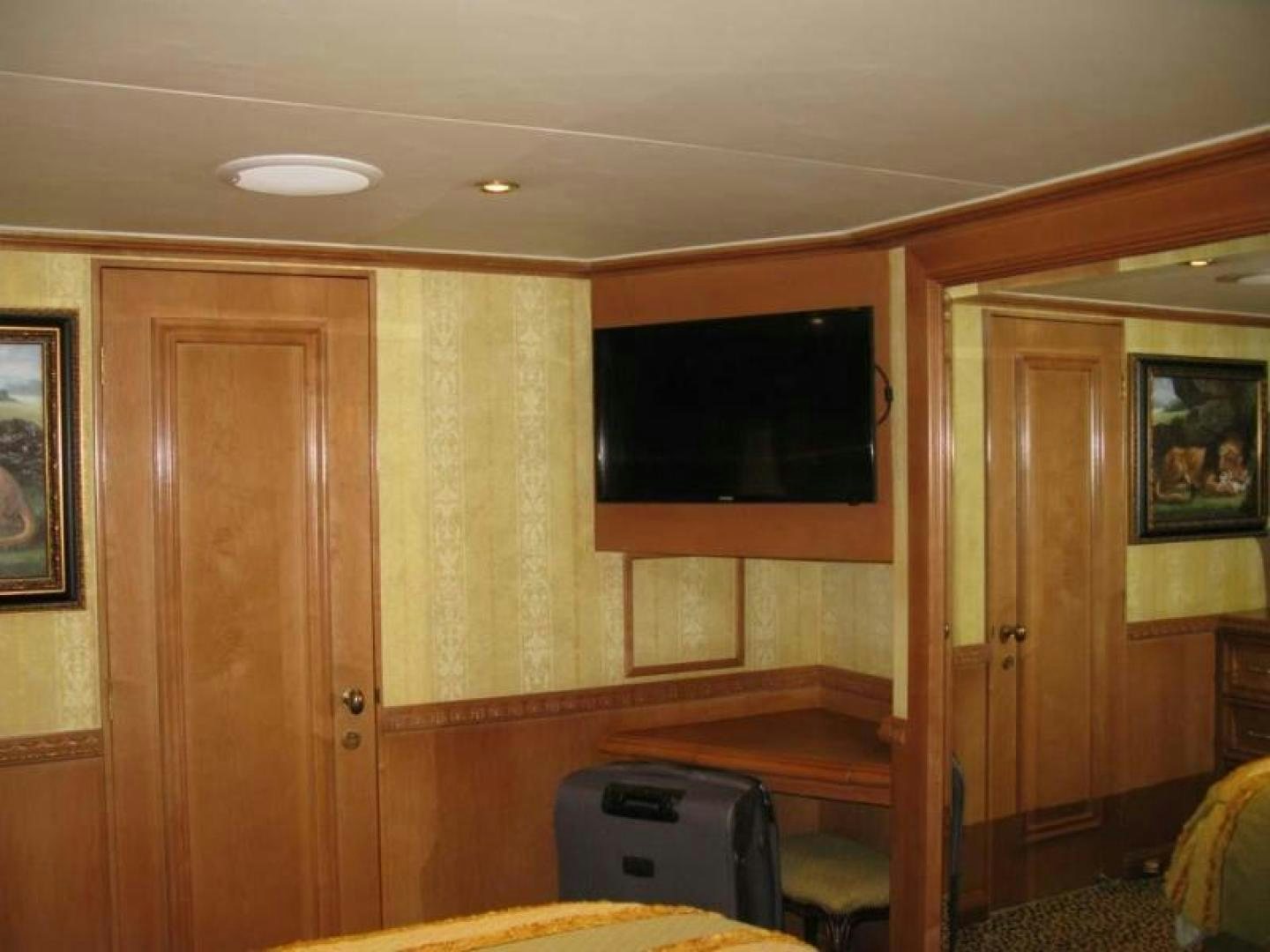 a room with a television and luggage aboard TRUE NORTH Yacht for Sale
