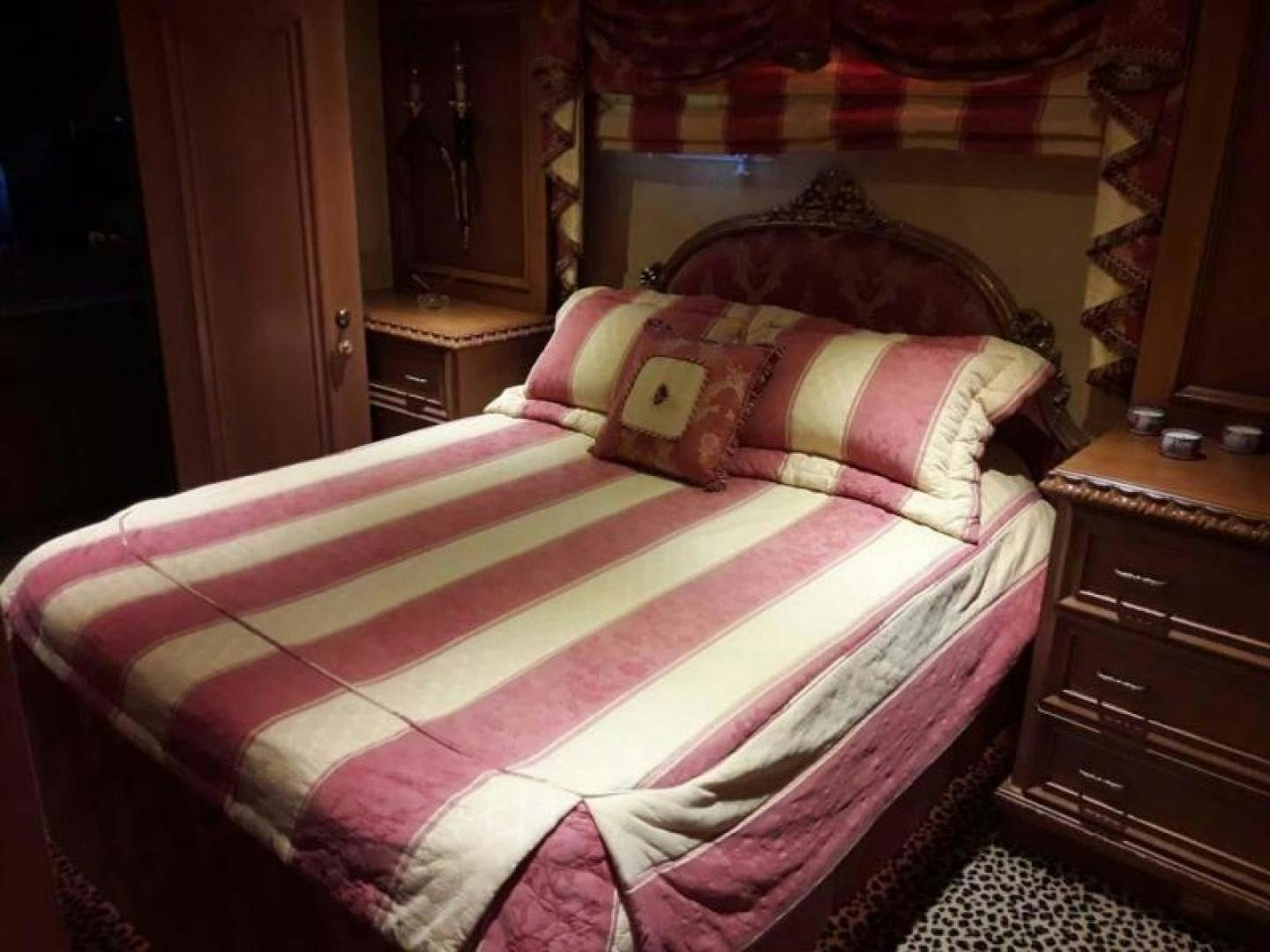 a bed with a pink and white comforter aboard TRUE NORTH Yacht for Sale