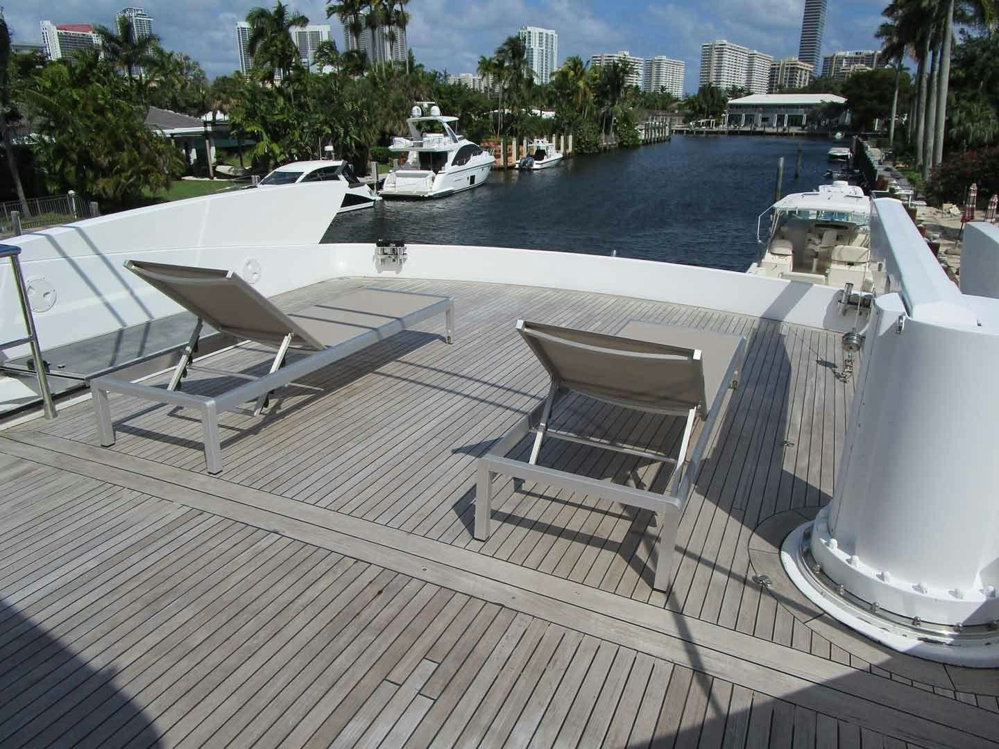 a deck with chairs and a body of water in the background aboard DEAR HENRI Yacht for Sale