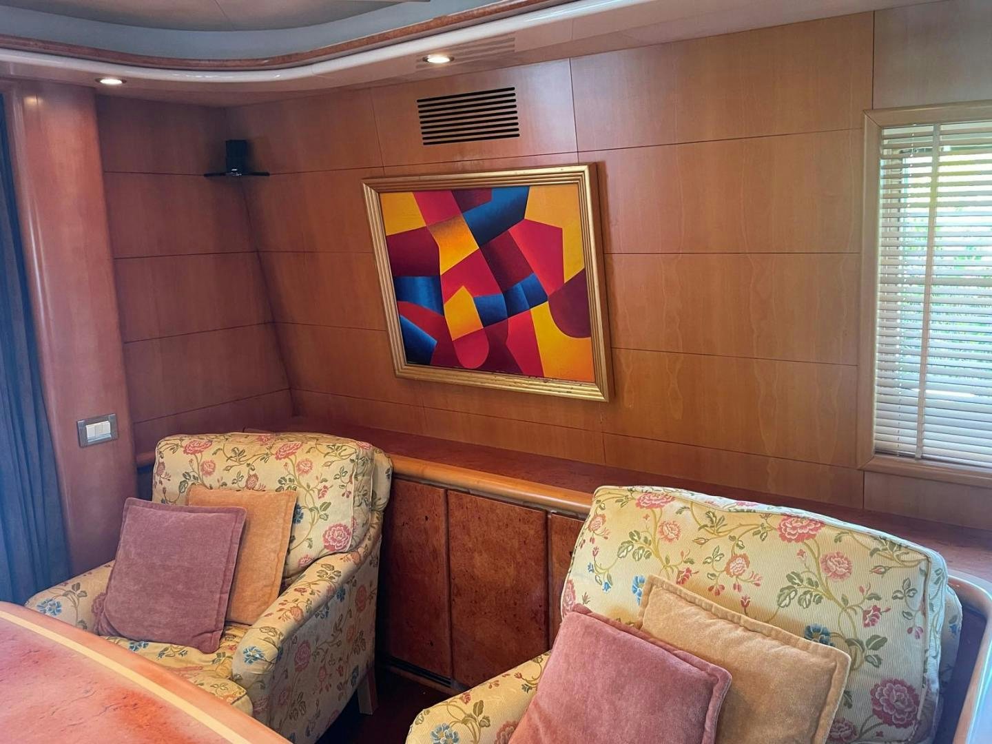 a room with a couch and a painting on the wall aboard DEAR HENRI Yacht for Sale