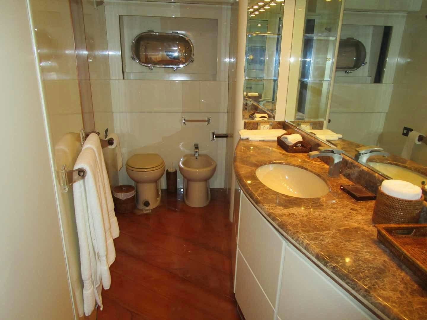 a bathroom with a sink toilet and a mirror aboard DEAR HENRI Yacht for Sale