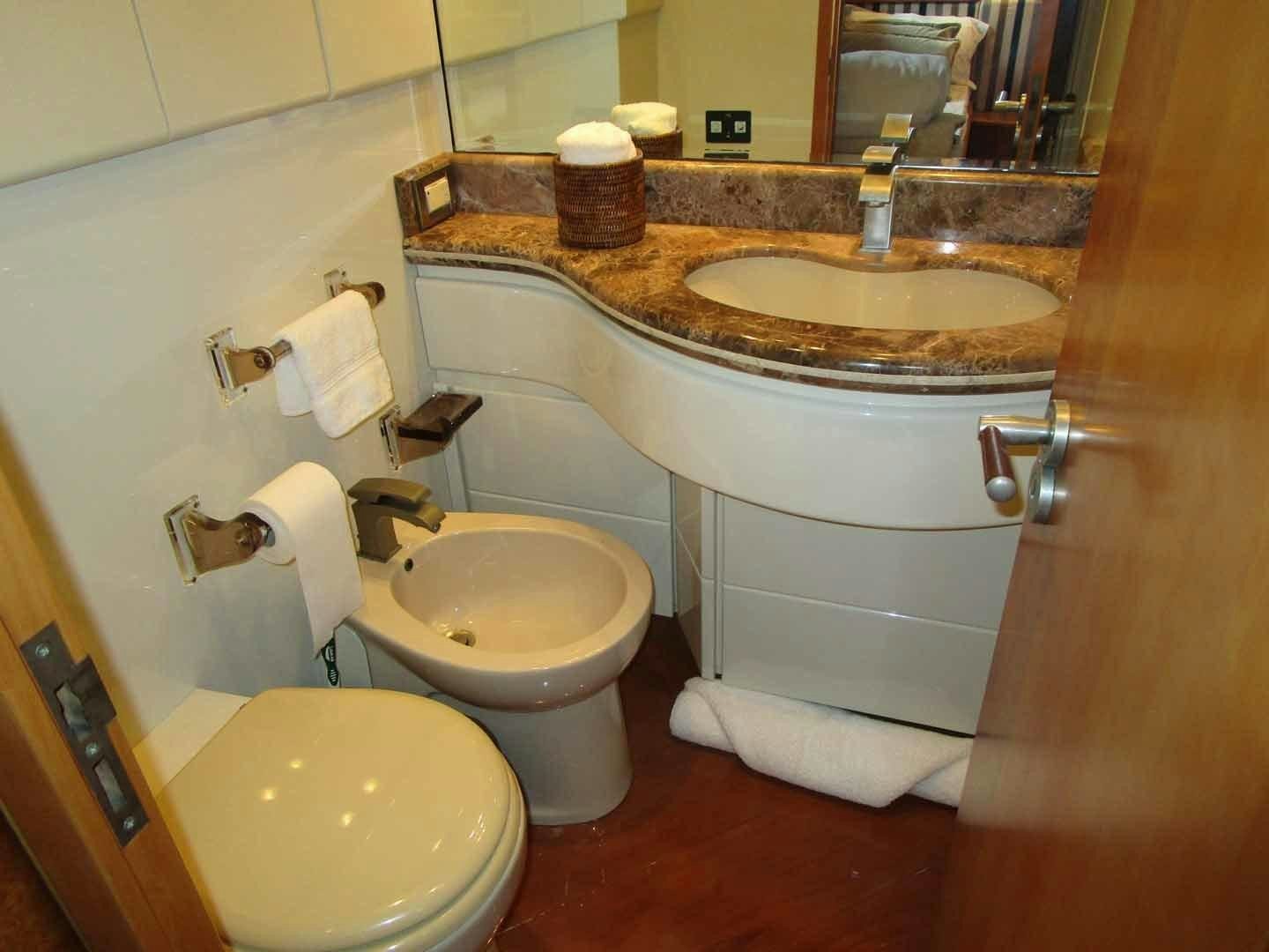 a bathroom with a sink toilet and a mirror aboard DEAR HENRI Yacht for Sale
