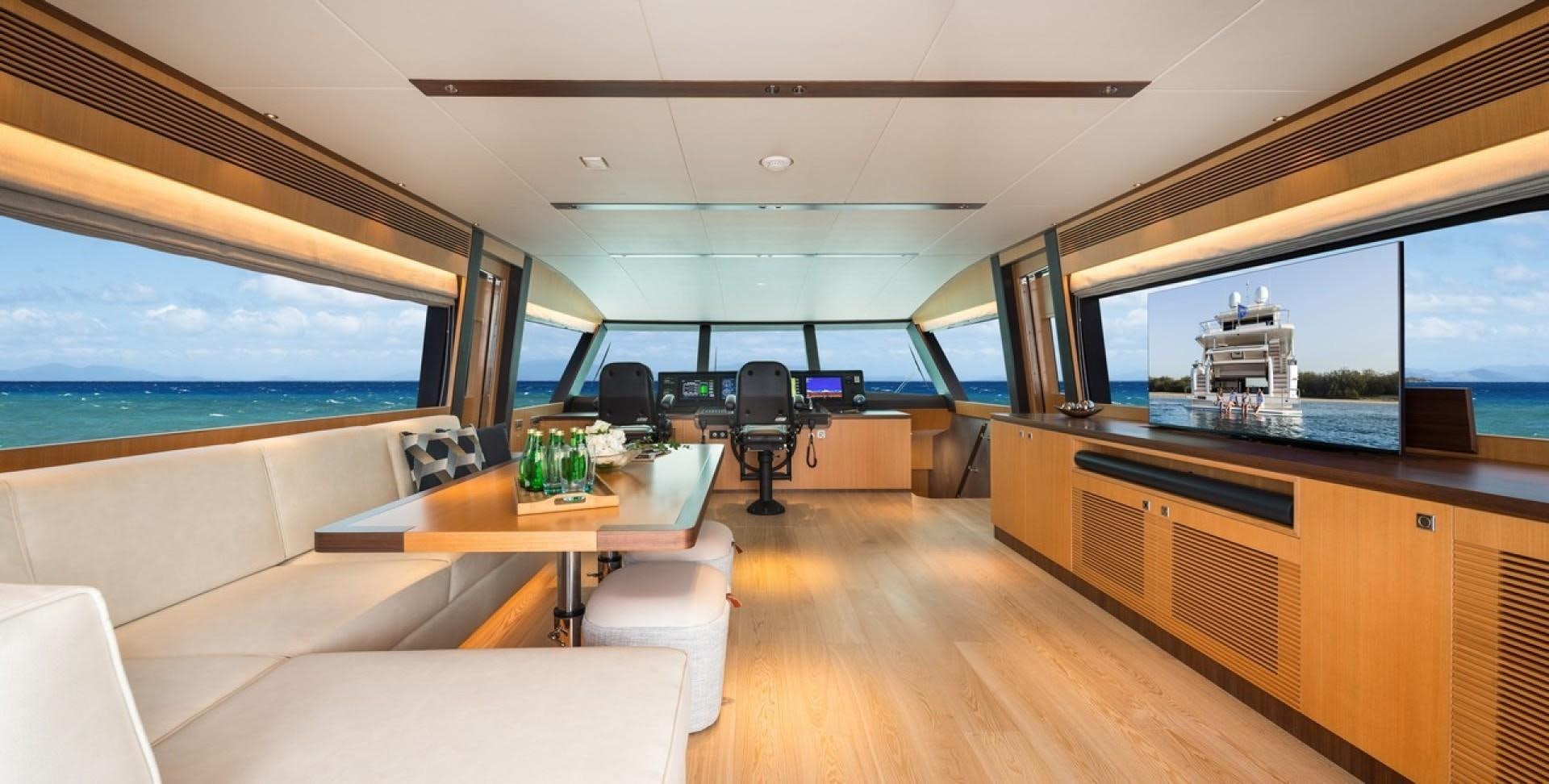 inside of a room with a large window and a table with chairs and a view of the ocean aboard PARABOLIC Yacht for Sale