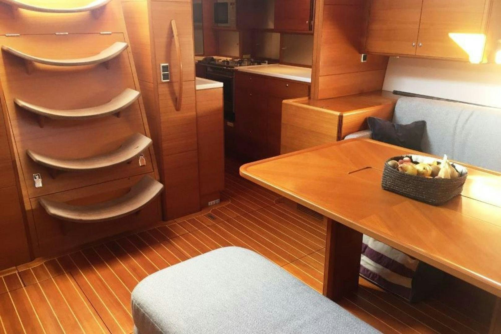 a kitchen with a table and a couch aboard XERES Yacht for Sale