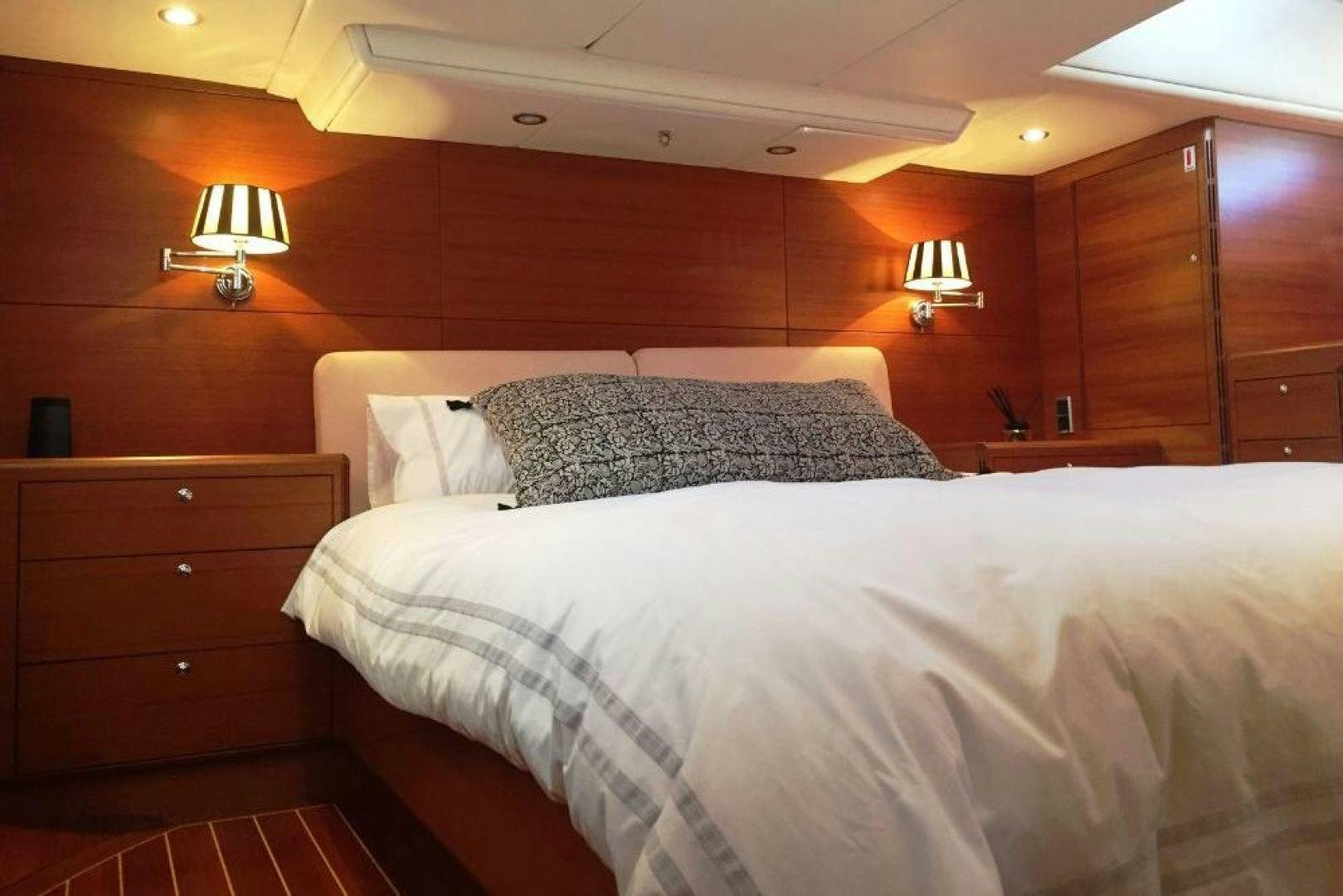 a bed with two lamps on either side of it aboard XERES Yacht for Sale