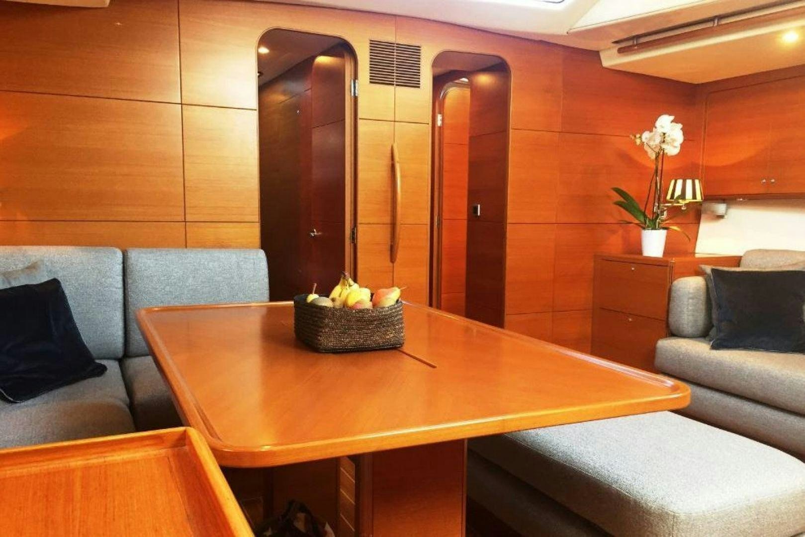 a room with a table and couch aboard XERES Yacht for Sale