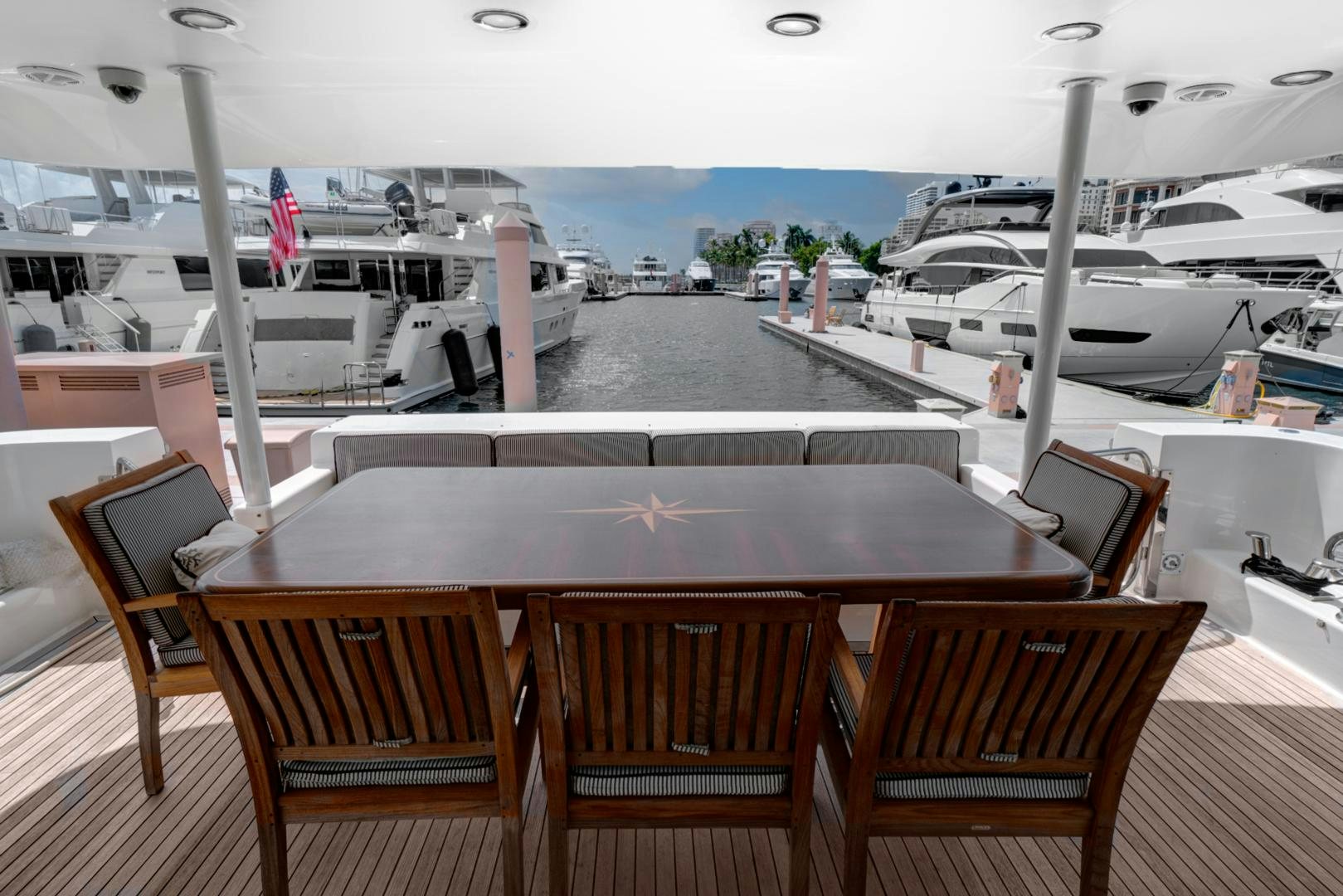 a table with chairs on it next to a window with boats on it aboard LADY B Yacht for Sale