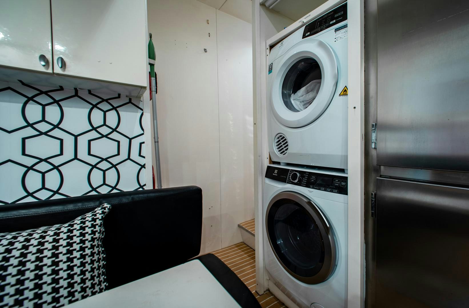 a room with a washing machine and a chair aboard SMILE Yacht for Sale