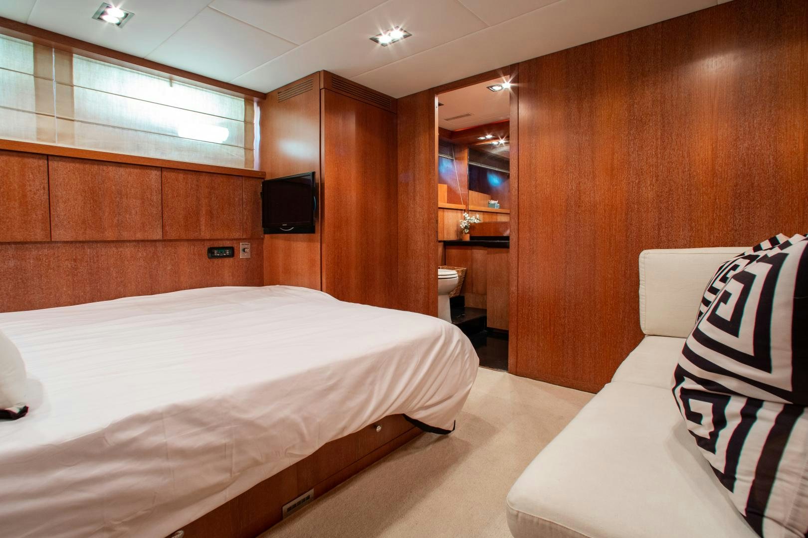 a room with a bed and a television aboard SMILE Yacht for Charter