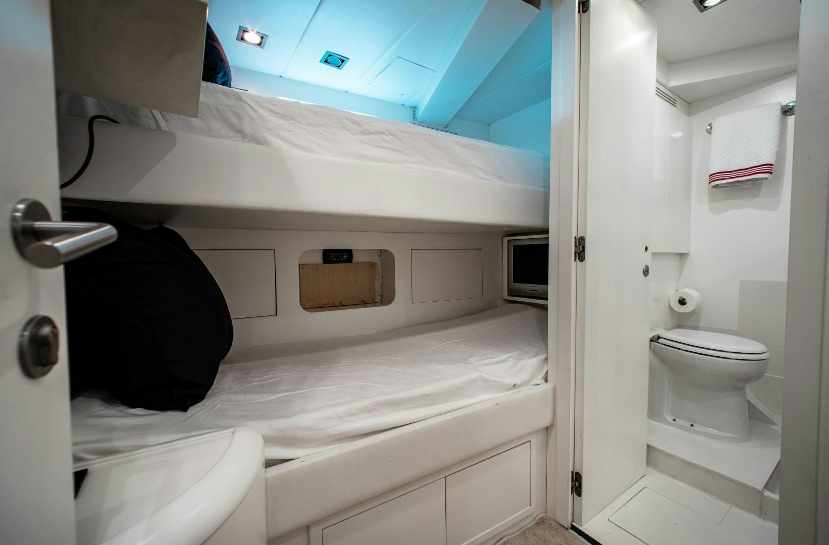 a small room with a bed and a small television aboard SMILE Yacht for Sale