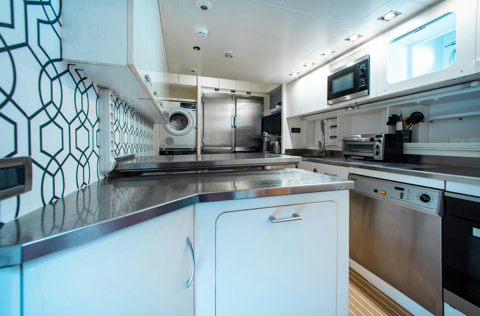 a kitchen with white cabinets aboard SMILE Yacht for Sale