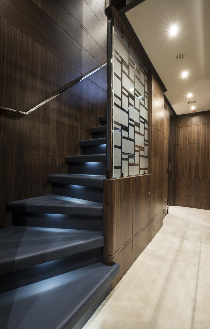 a wood staircase with a wood railing aboard JODI ANN Yacht for Sale