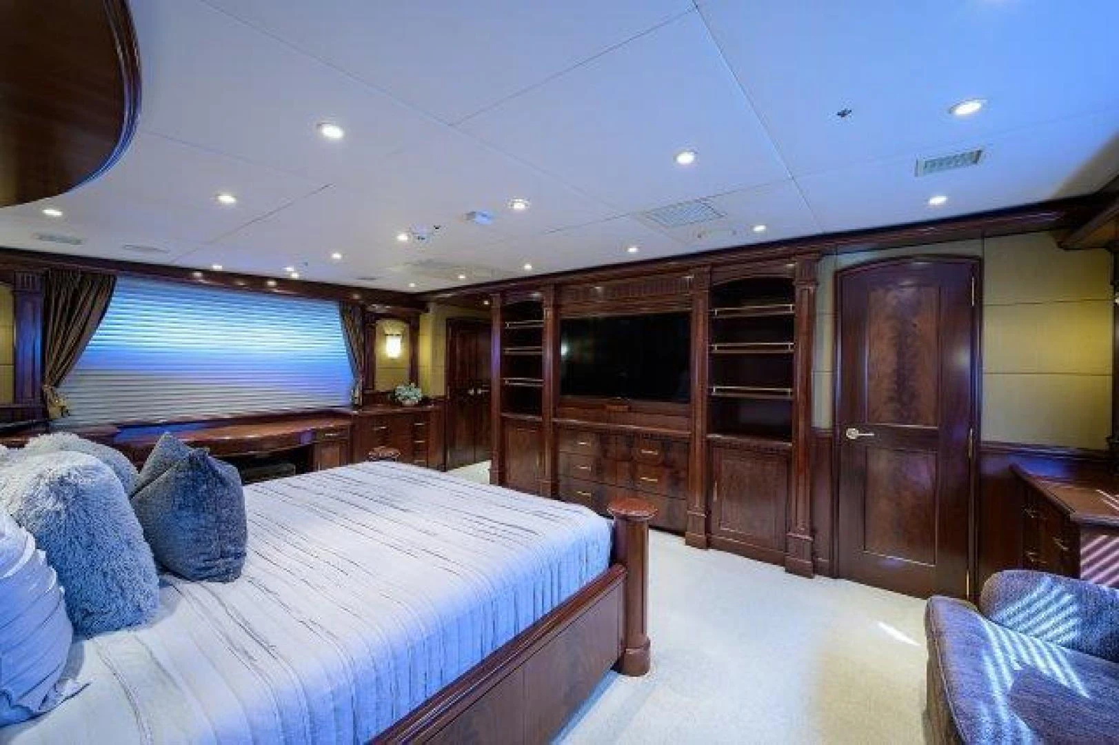 a bedroom with a bed and a wood cabinet aboard REBECCA Yacht for Sale