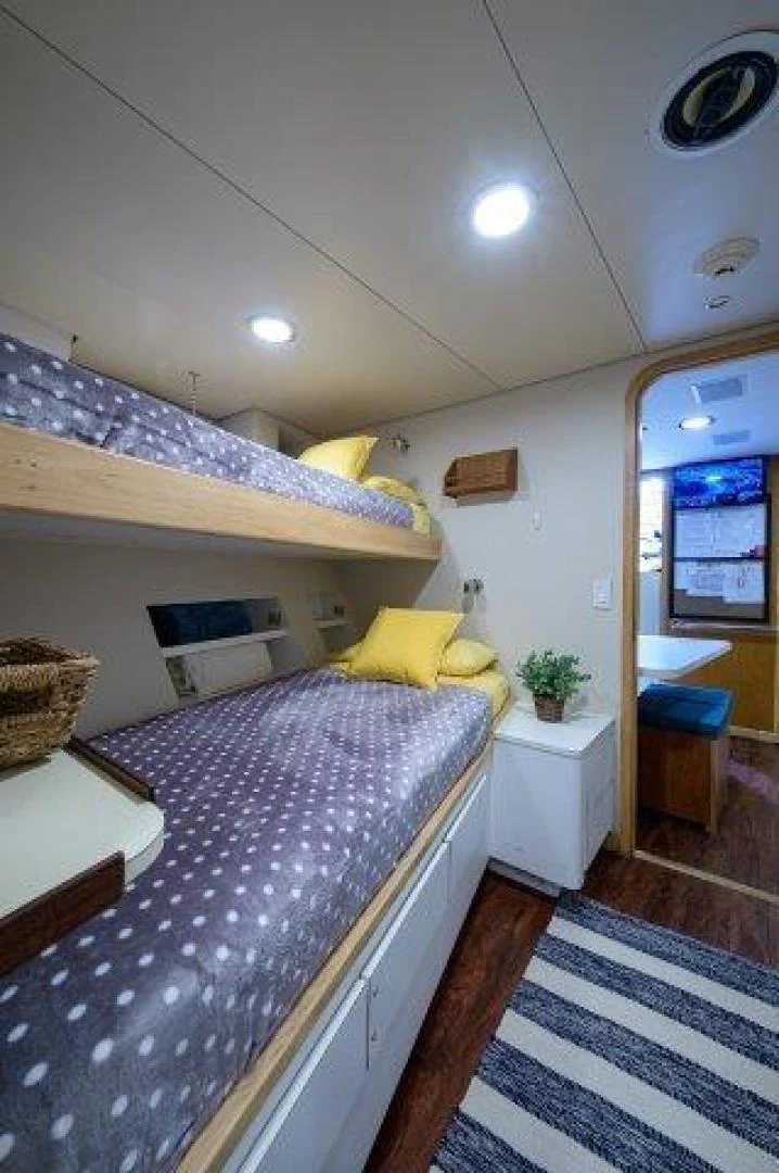 a bedroom with a bed and a table aboard REBECCA Yacht for Sale