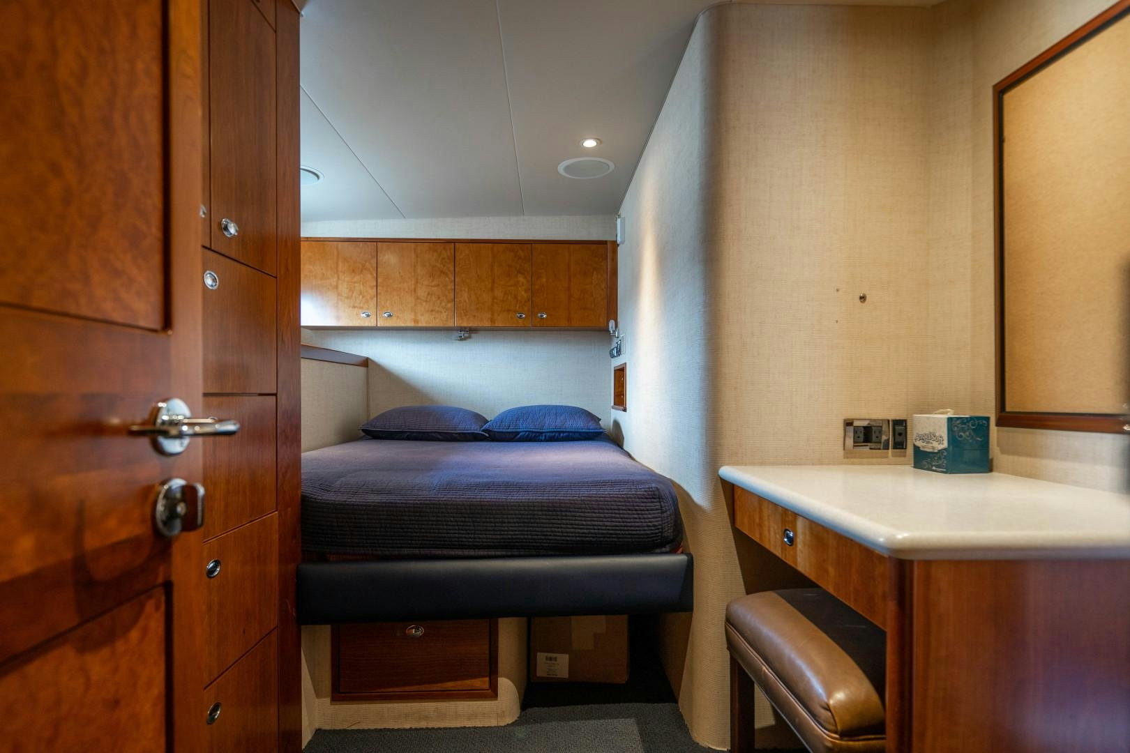 a room with a bed and desk aboard LEGACY Yacht for Sale