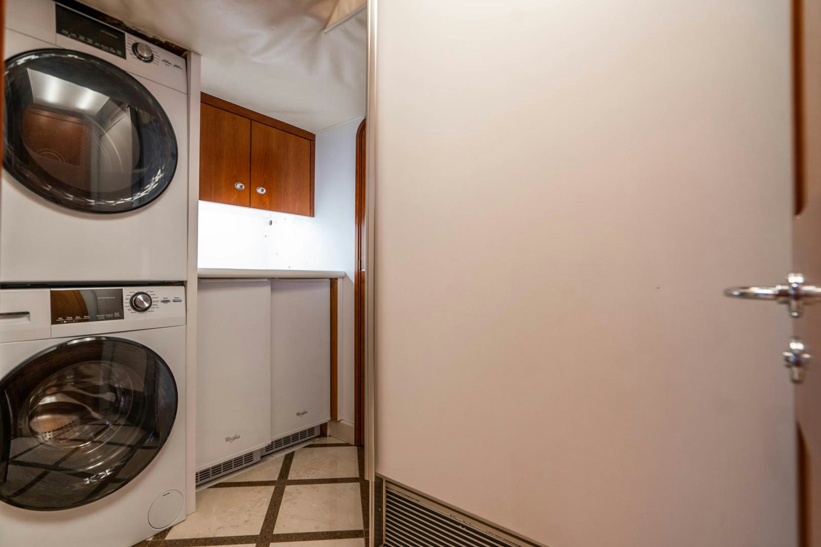 a white kitchen with a washing machine aboard LEGACY Yacht for Sale