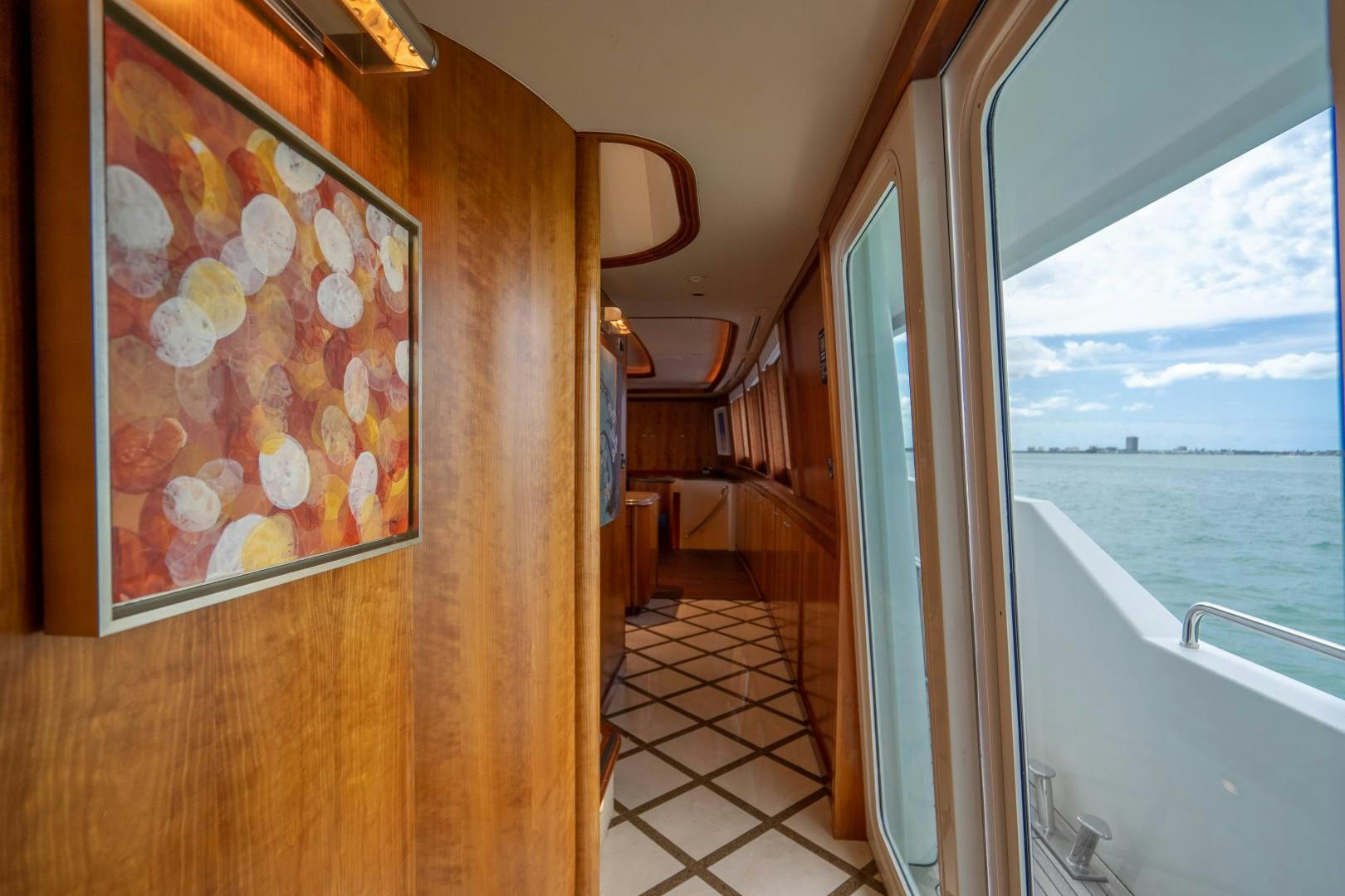 a room with a large window and a large painting on the wall aboard LEGACY Yacht for Sale