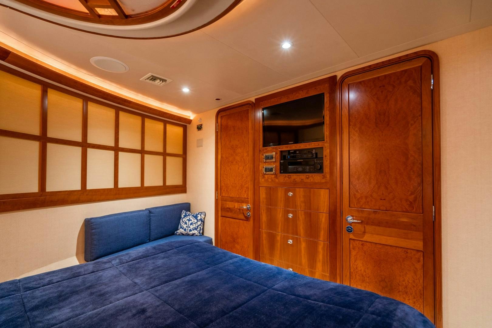 a bed with a blue bed spread aboard LEGACY Yacht for Sale