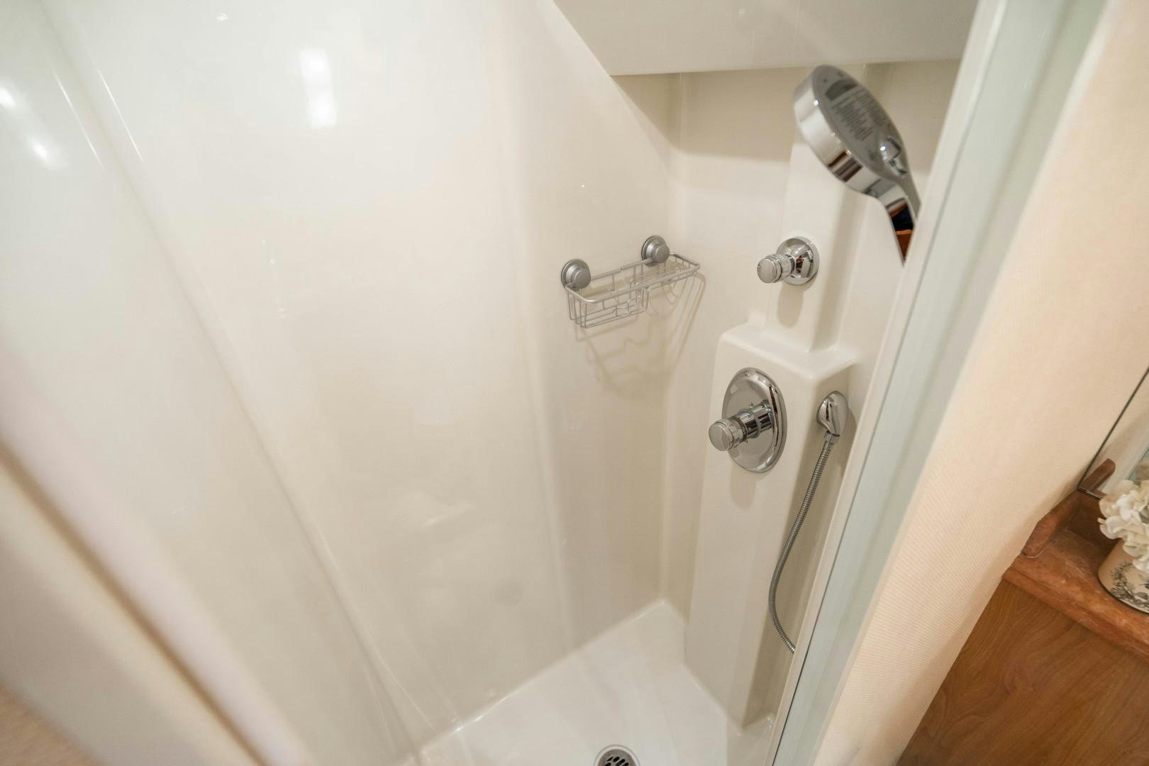 a shower with a white wall aboard LEGACY Yacht for Sale