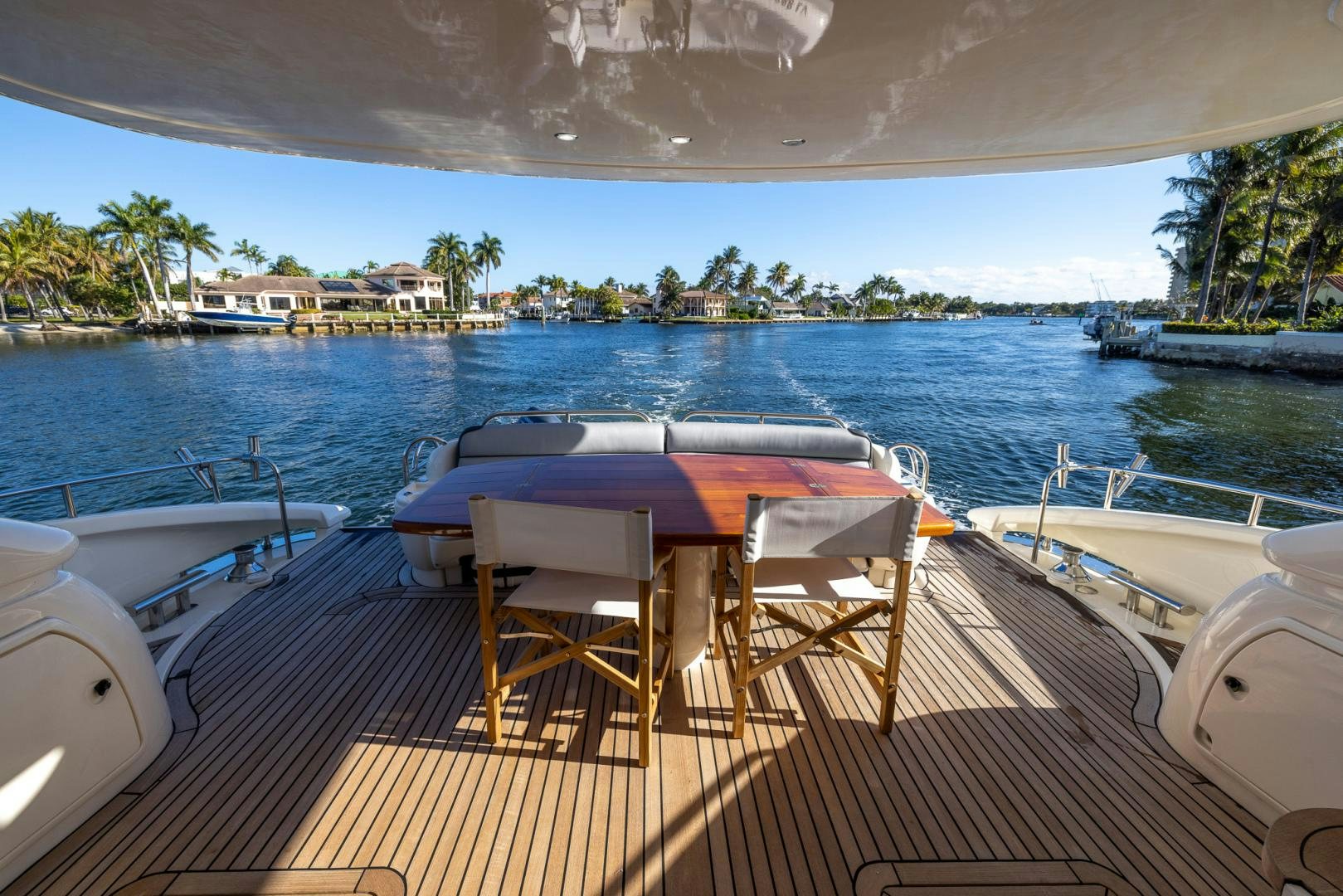a table and chairs on a deck overlooking a body of water aboard SIROCCO Yacht for Sale