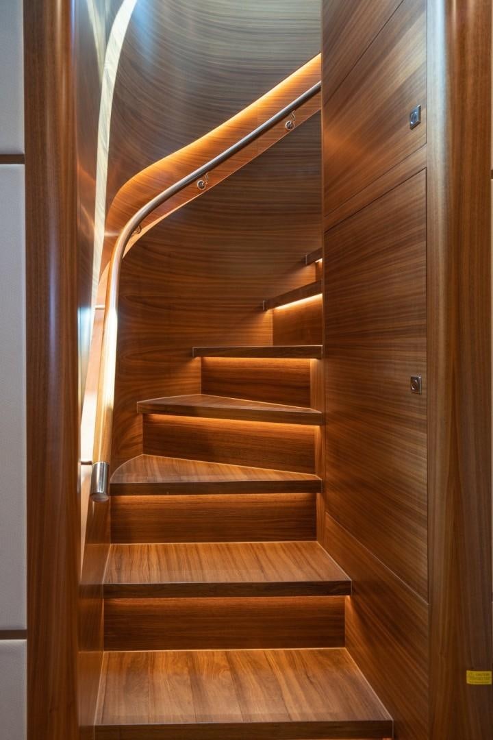 a wooden staircase with a railing aboard TI AMO Yacht for Sale