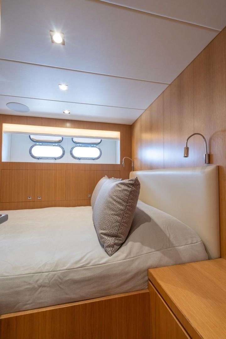 a bed with a white pillow and a wooden headboard aboard TI AMO Yacht for Sale