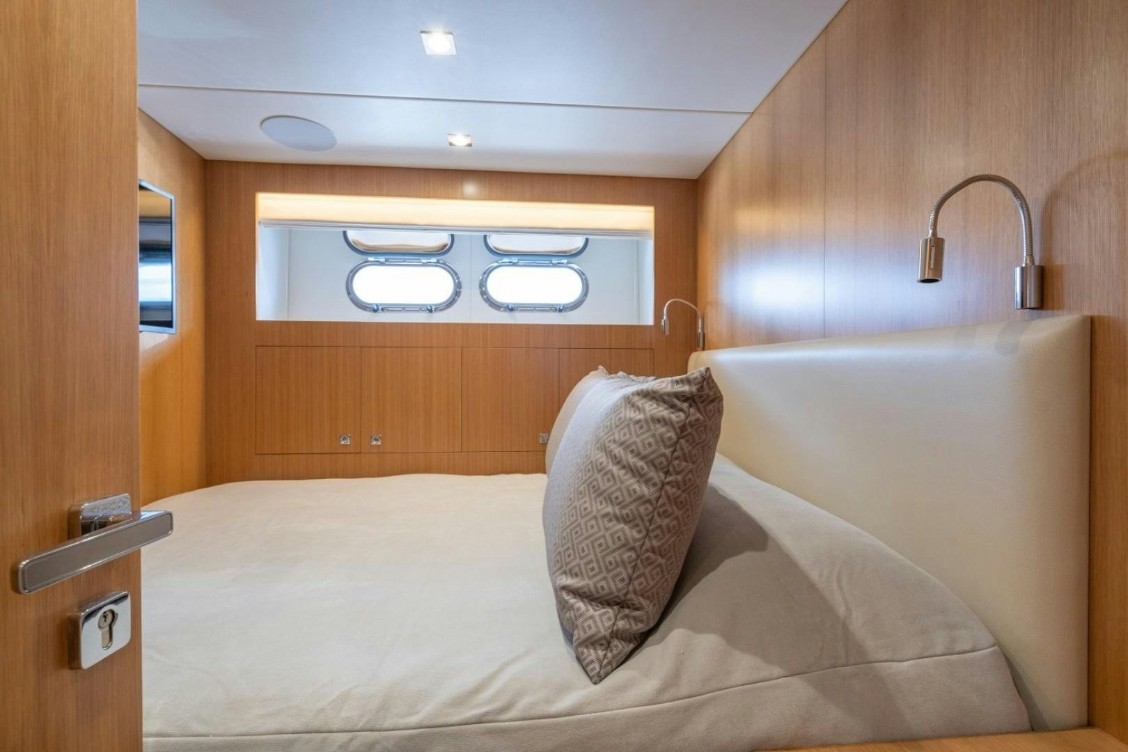 a bed with a white pillow and a wooden cabinet aboard TI AMO Yacht for Sale