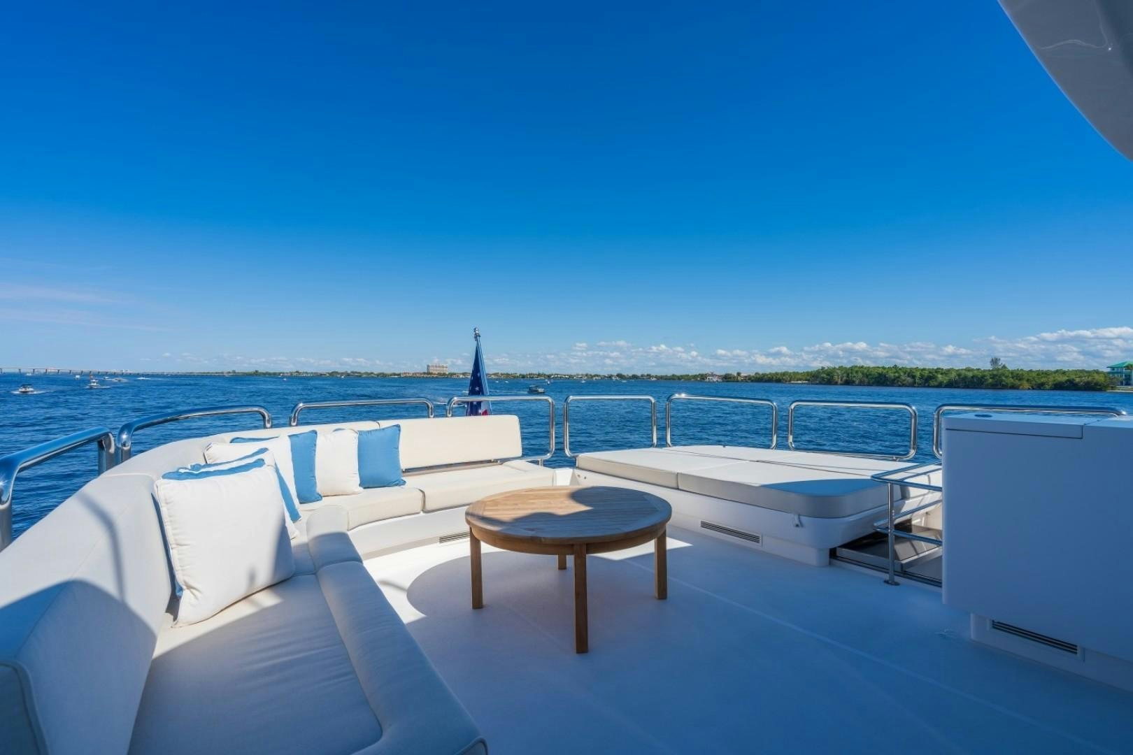 a table and chairs on a deck overlooking a body of water aboard TI AMO Yacht for Sale