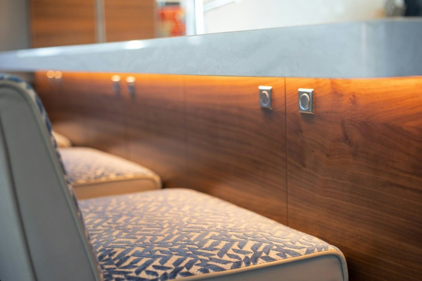 a blue and orange striped pillow on a brown couch aboard TI AMO Yacht for Sale