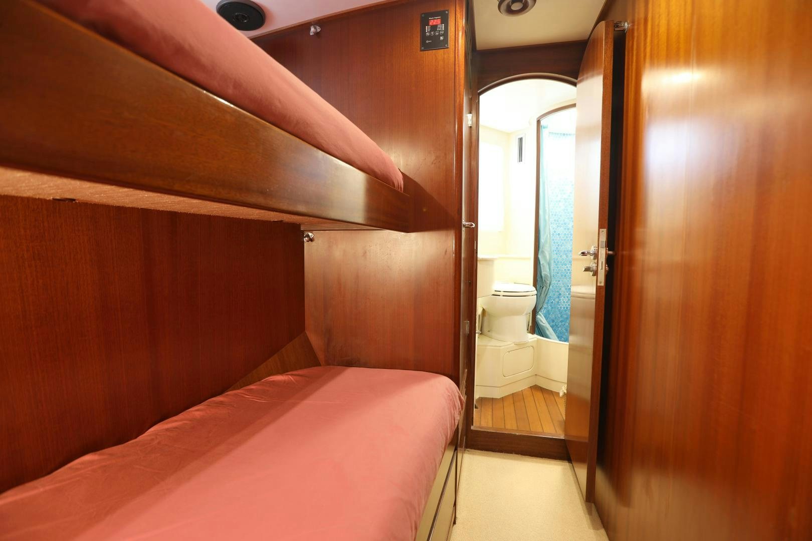 a room with a bed and a door aboard IRON MONKEY Yacht for Sale