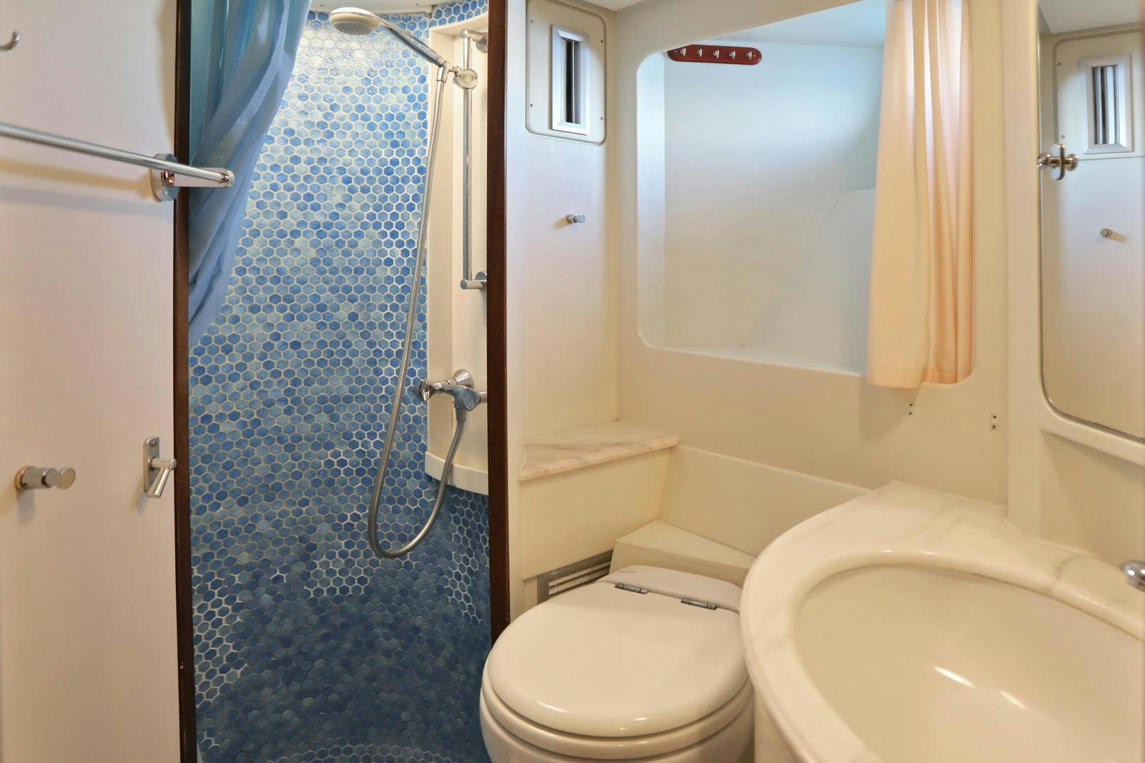 a bathroom with a shower curtain and toilet aboard IRON MONKEY Yacht for Sale