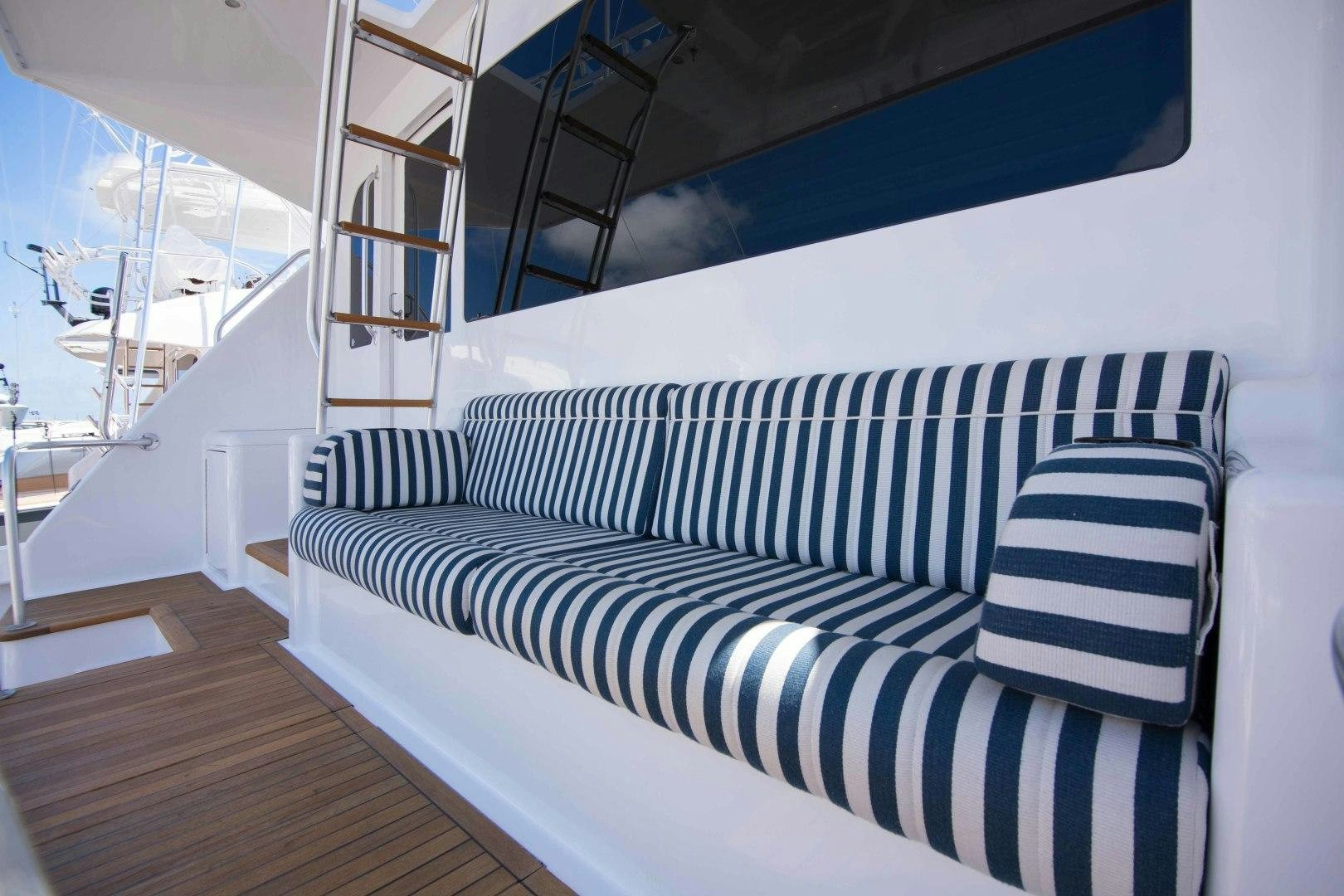 a bed with a striped sheet aboard LUNA Yacht for Sale