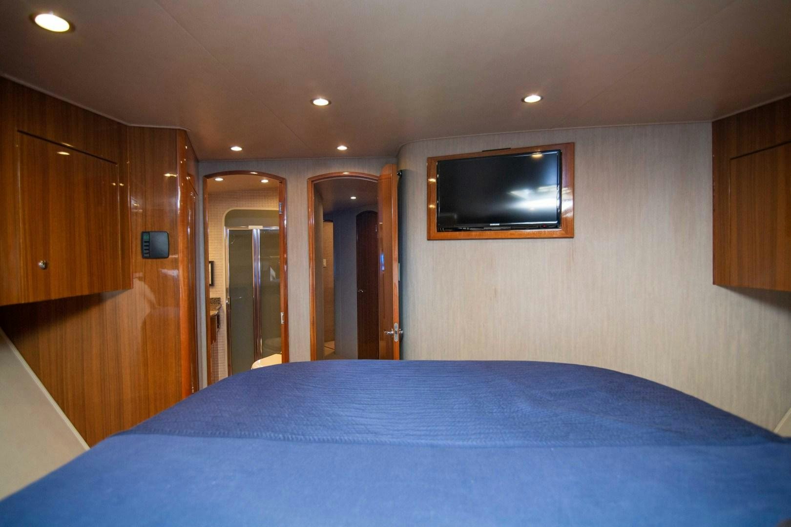 a bedroom with a television on the wall aboard LUNA Yacht for Sale