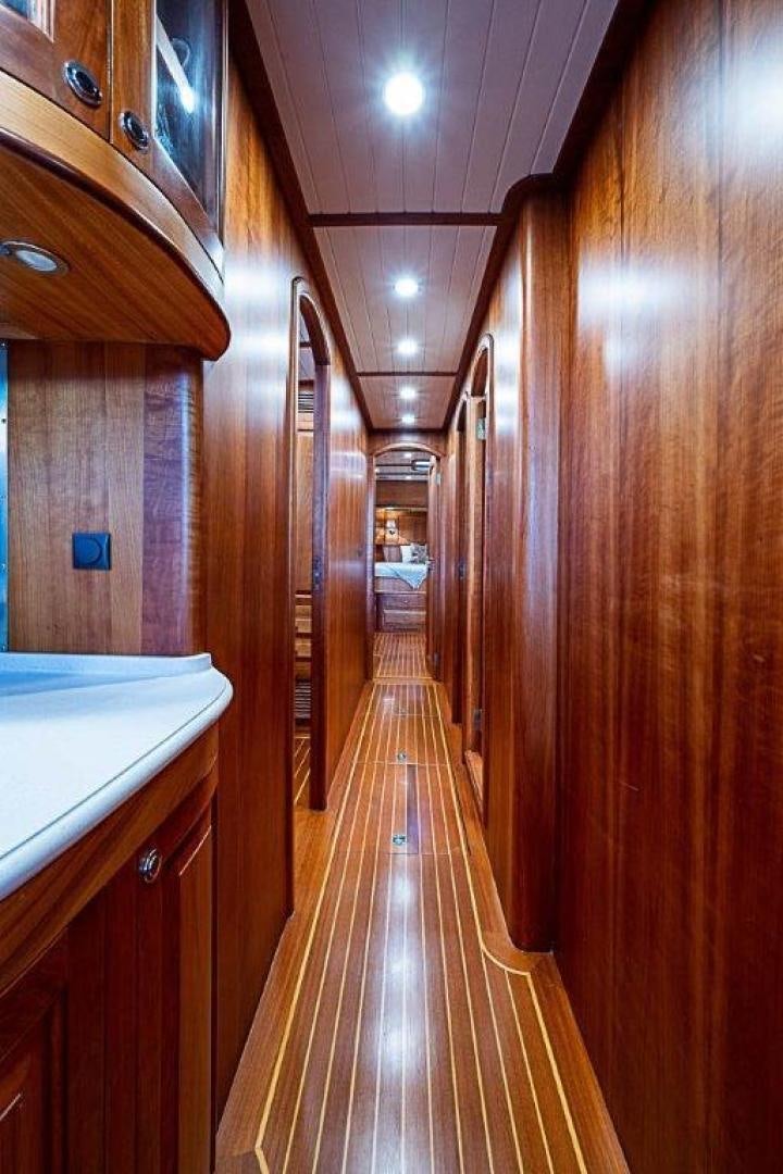 a long hallway with wood cabinets aboard NAMHARA Yacht for Sale