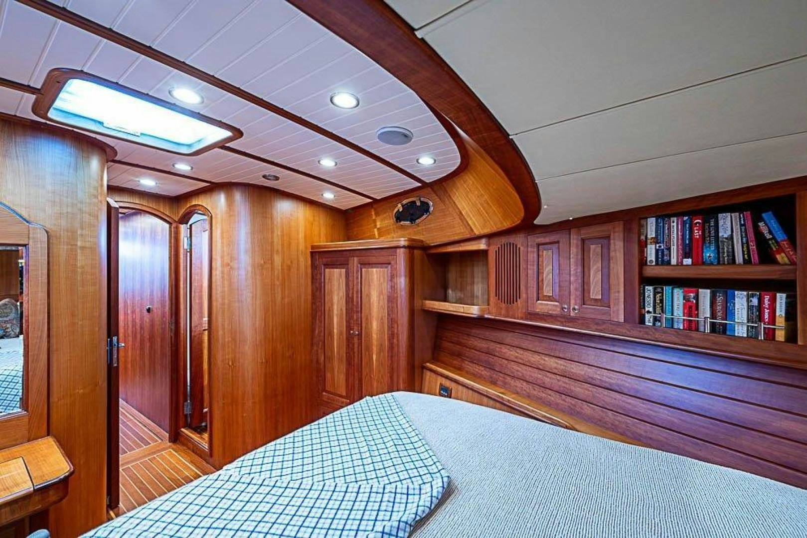 a bedroom with a bookcase and a bed aboard NAMHARA Yacht for Sale
