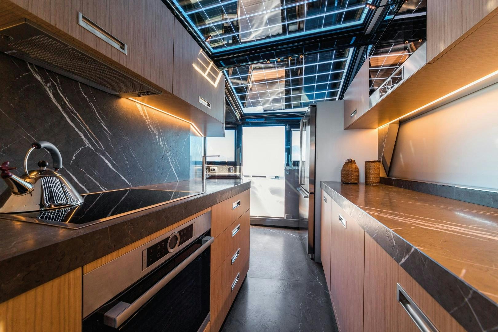 a kitchen with a large island aboard BOOMSHAKALAKA Yacht for Sale