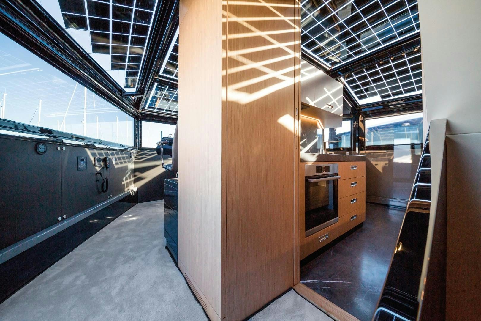 a room with a large glass wall and a microwave oven aboard BOOMSHAKALAKA Yacht for Sale