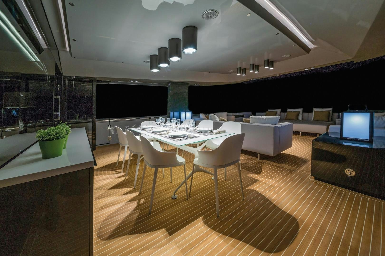 a room with a table chairs and a tv aboard BOOMSHAKALAKA Yacht for Sale