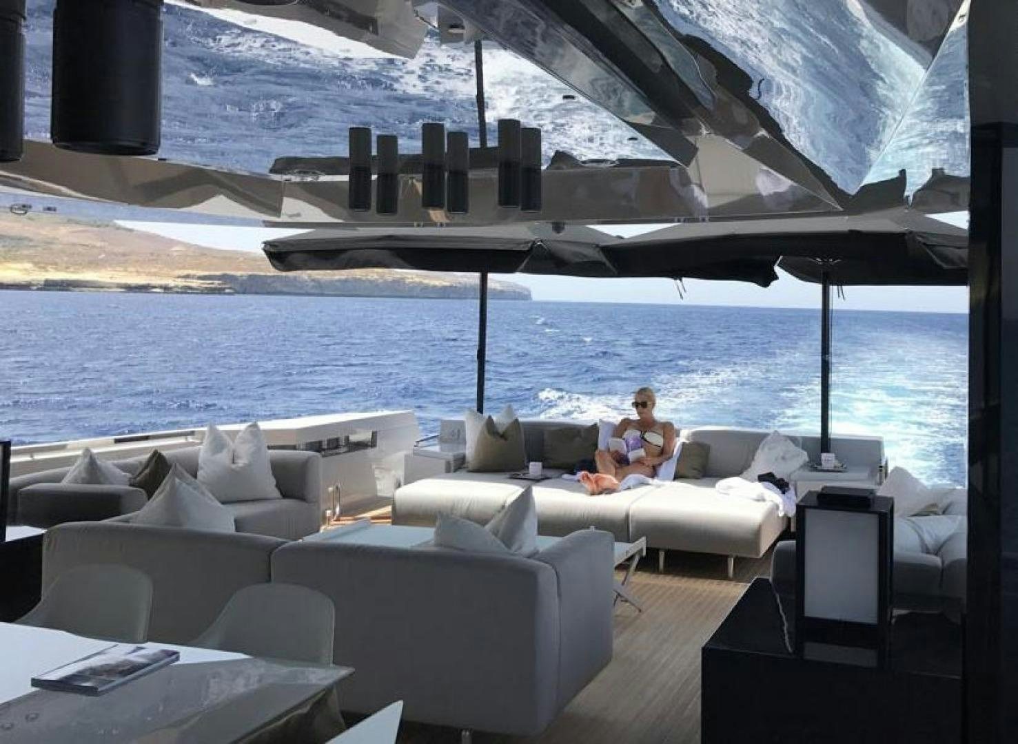 a couple of people sitting on a couch on a beach aboard BOOMSHAKALAKA Yacht for Sale