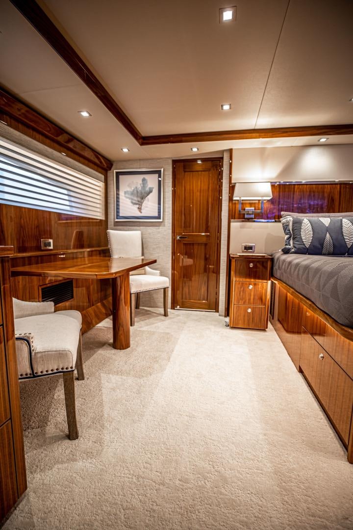 a bedroom with a bed and desk aboard INDIGO Yacht for Sale