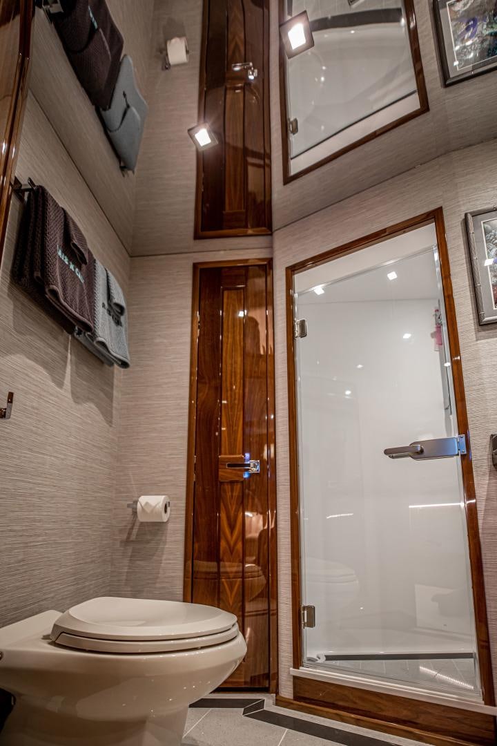 a bathroom with a toilet and a door aboard INDIGO Yacht for Sale