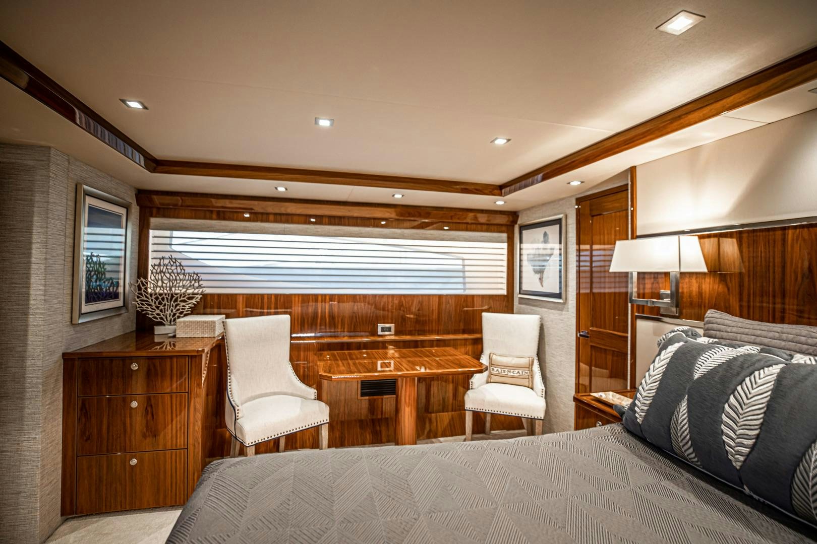 a bedroom with a bed and a chair aboard INDIGO Yacht for Sale