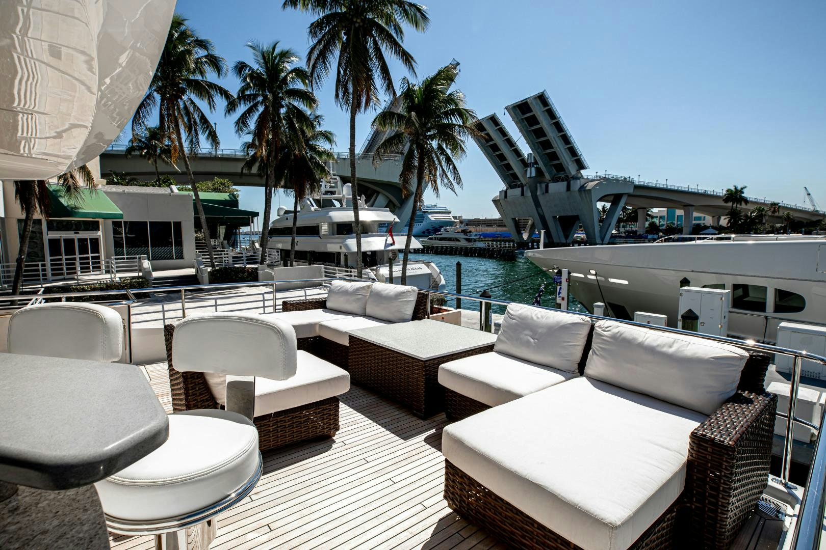 a lounge area with lounge chairs and palm trees aboard INDIGO Yacht for Sale