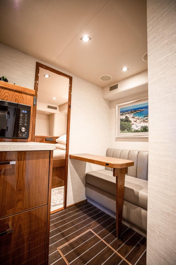a room with a table and a tv aboard INDIGO Yacht for Sale