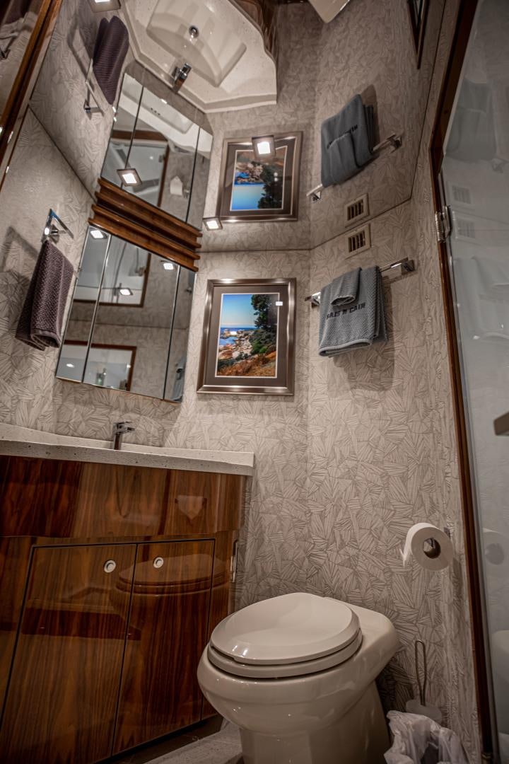 a bathroom with a toilet and a mirror aboard INDIGO Yacht for Sale