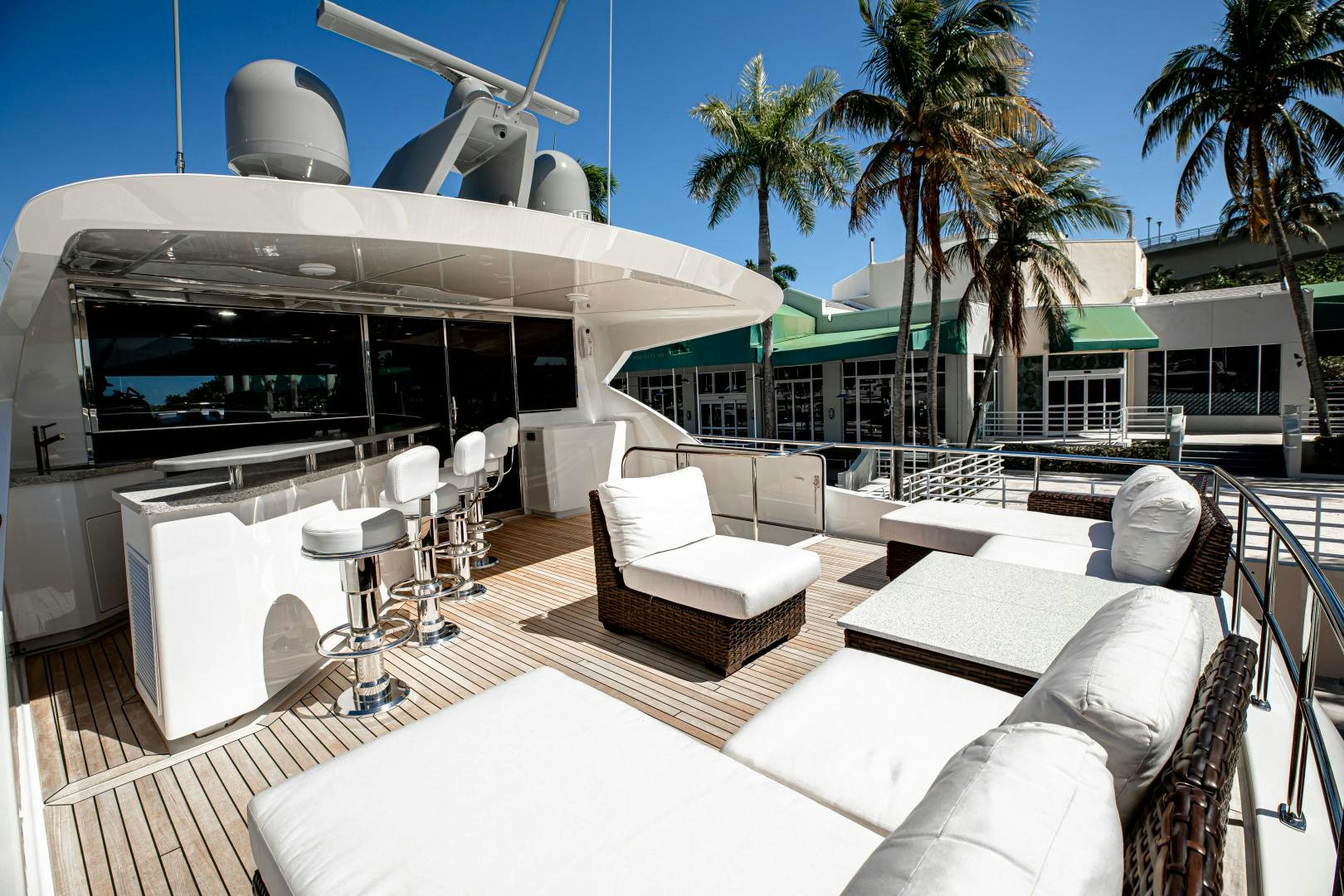 a lounge area with lounge chairs and a large white lounge chair aboard INDIGO Yacht for Sale